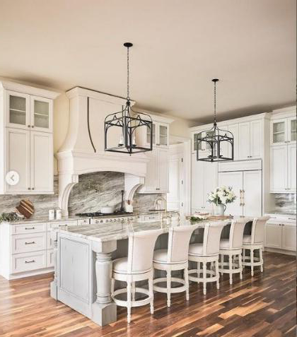 Country style kitchen with white cabinets, wooden ceiling, and decorative elements.