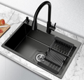 Black kitchen sink with faucet on a white countertop